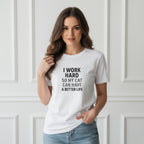 Woman wearing a white t-shirt with text, standing against a white paneled wall.